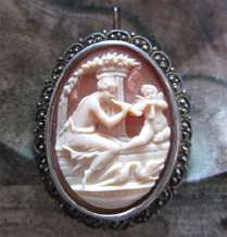 Well carved shell image of Venus & Cupped playing on flute Unmarked vermeil Sterling Silver Brooch circa 1910.